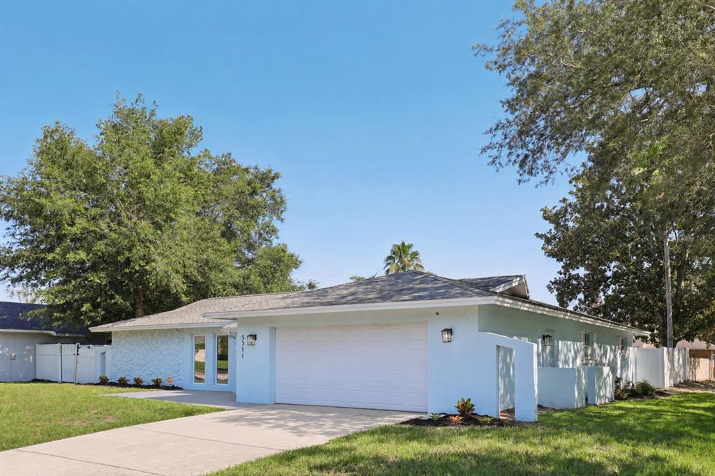 A single-story house with white stone siding, a gray shingled roof, and an attached garage — 5311 JENNIFER PLACE, ORLANDO, FL
