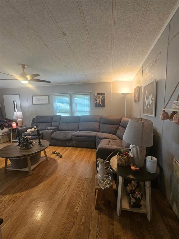 A living room features a large gray sectional sofa, wood flooring, and a ceiling fan — 475 PAPAYA CIRCLE, SEBASTIAN, FL
