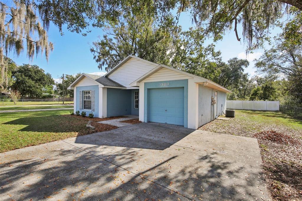 A single-story house with blue exterior walls, a white gable, and a concrete driveway — 3501 W REYNOLDS STREET, PLANT CITY, FL