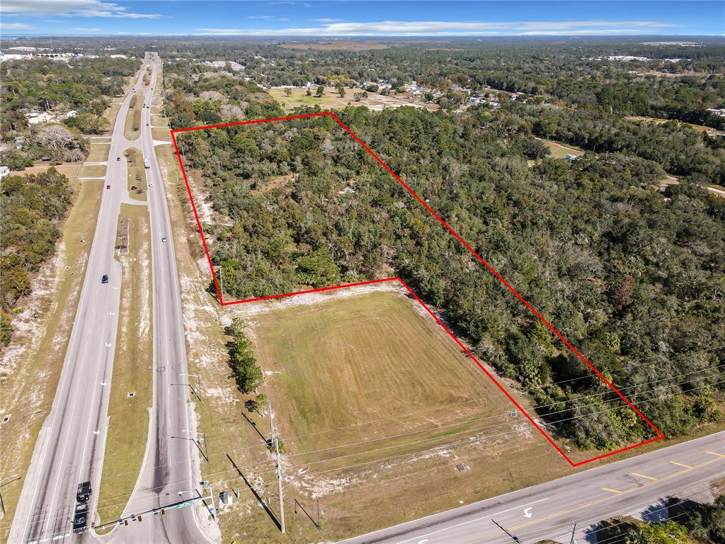 An aerial view shows a rectangular plot of land outlined in red near a highway — 0000 LITTLE, HUDSON, FL