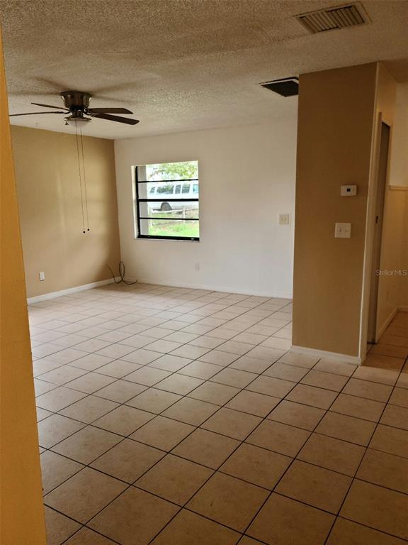 An empty room with tiled floors, a ceiling fan, and a window looking outside — 2712 TORTOISE CV, WINTER PARK, FL