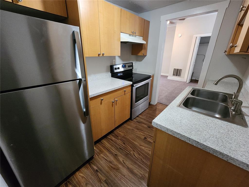 A kitchen features light wood cabinets, stainless steel appliances, and a double-basin sink — 2110 W 41ST STREET, JACKSONVILLE, FL