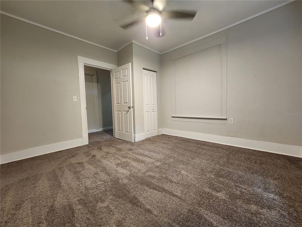 An empty bedroom features gray walls, brown carpeting, a ceiling fan, and two white doors — 2110 W 41ST STREET, JACKSONVILLE, FL