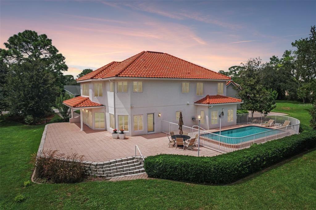 A two-story house with a red tile roof, a patio, and a fenced swimming pool — 5198 LEGEND HILLS LANE, SPRING HILL, FL