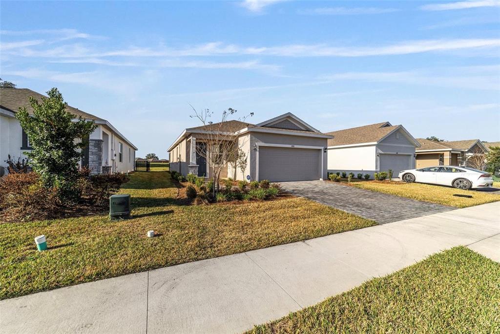 A single-story suburban house with a gray garage and a paved driveway — 5450 NW 46TH LANE ROAD, OCALA, FL