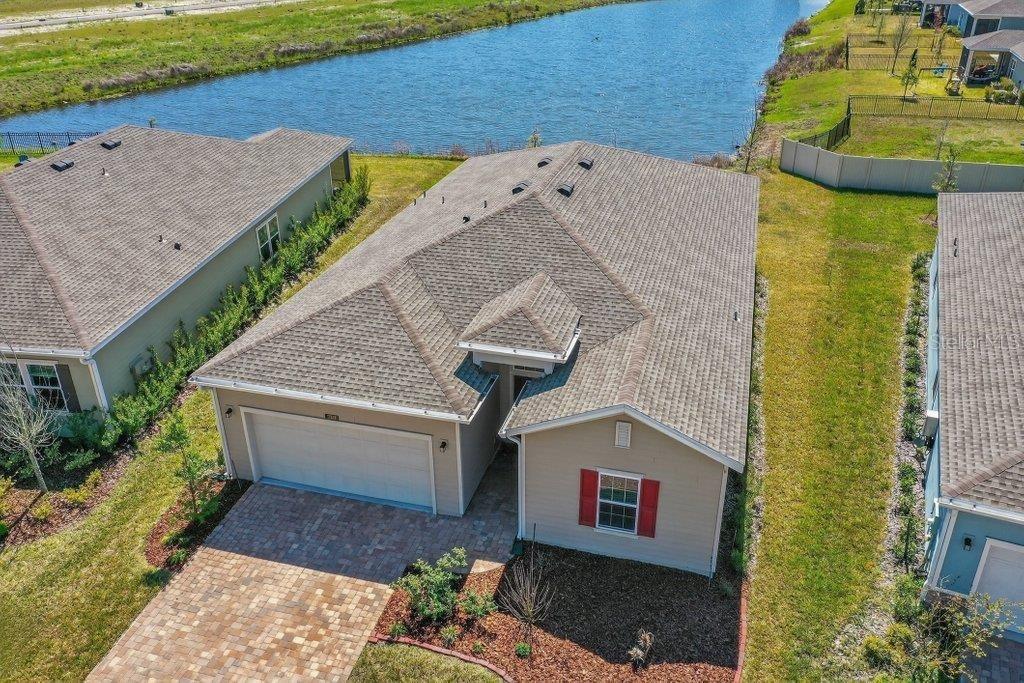 An aerial view of a single-story house with a tan exterior, red shutters, and garage — 210 WHITE RABBIT RUN, ST AUGUSTINE, FL
