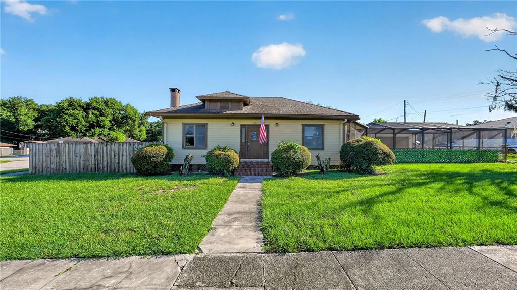A single-story house with tan siding, a brown roof, and a chimney sits on a lawn — 116 W ARBORVITAE LANE, POLK CITY, FL