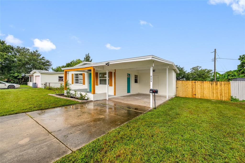 A single-story house with a carport, a concrete driveway, and a wooden privacy fence — 8176 65TH STREET N, PINELLAS PARK, FL