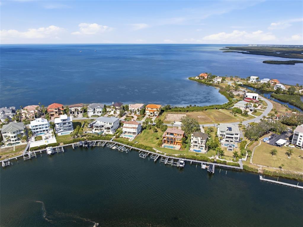 An aerial view shows waterfront homes with private docks along a coastal inlet — 26 HARBORPOINTE DR, PORT RICHEY, FL