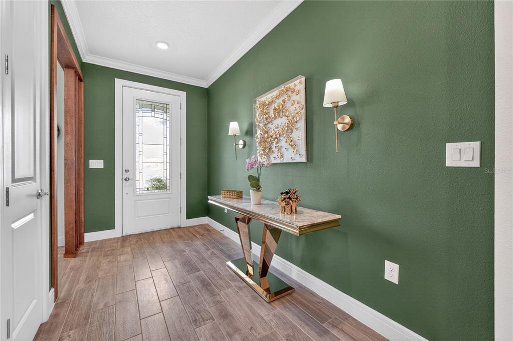 An entryway features a green wall, a marble-topped console table, and a white front door — 2873 CHERRY BLOSSOM LOOP, ST CLOUD, FL
