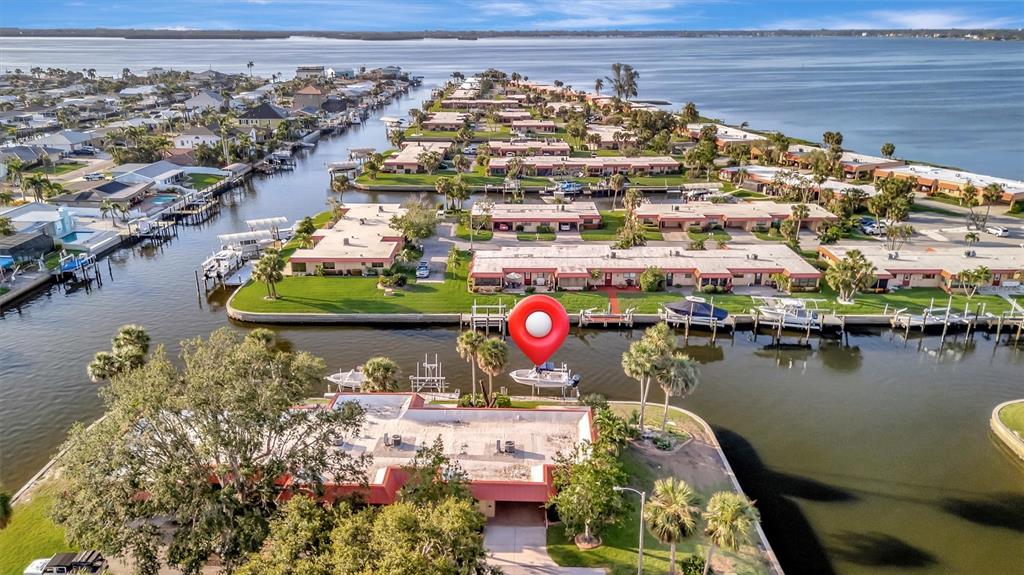 An aerial view shows waterfront residential buildings with private boat docks along a canal — 4096 EL DORADO COVE, BRADENTON, FL