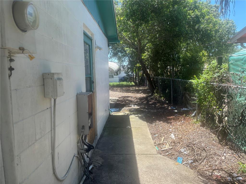 A concrete walkway runs alongside the white block exterior wall of a house — 8648 FOX HOLLOW DRIVE, PORT RICHEY, FL