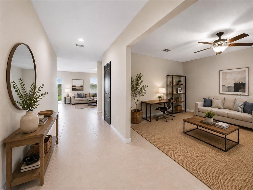 A hallway leads to a living area with a desk, sofa, and neutral tile flooring — 1507 GOLDEN GLOW DR, RUSKIN, FL