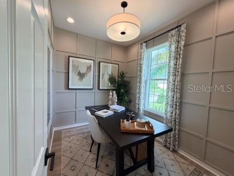 A home office features a dark wood desk, paneled walls, and a patterned area rug — 2442 PINWHERRY STREET NW, PALM BAY, FL