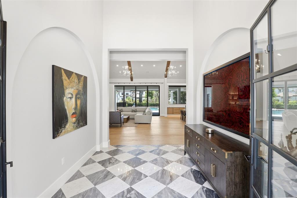 A foyer with a checkered marble floor leads into a living room with vaulted ceilings — 1206 SUTTER AVENUE, GOTHA, FL