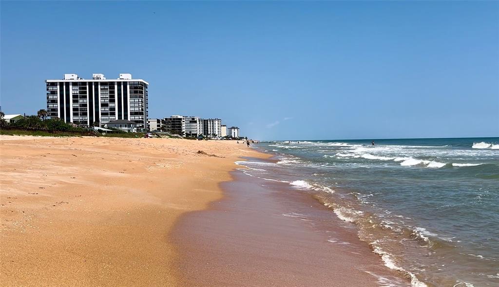 A sandy beach stretches along the coastline toward a row of high-rise apartment buildings — 1239 OCEAN SHORE BOULEVARD UNIT 2E5, ORMOND BEACH, FL