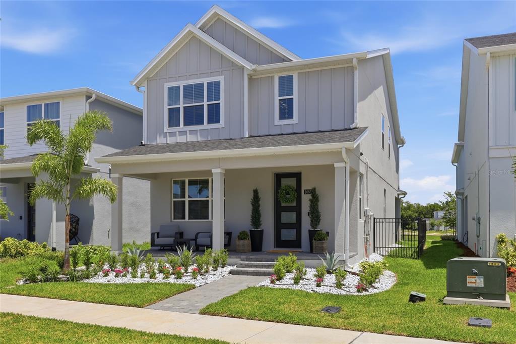 A two-story house with light gray siding, a covered front porch, and a landscaped yard — 1663 CROWNCREST DRIVE, APOPKA, FL