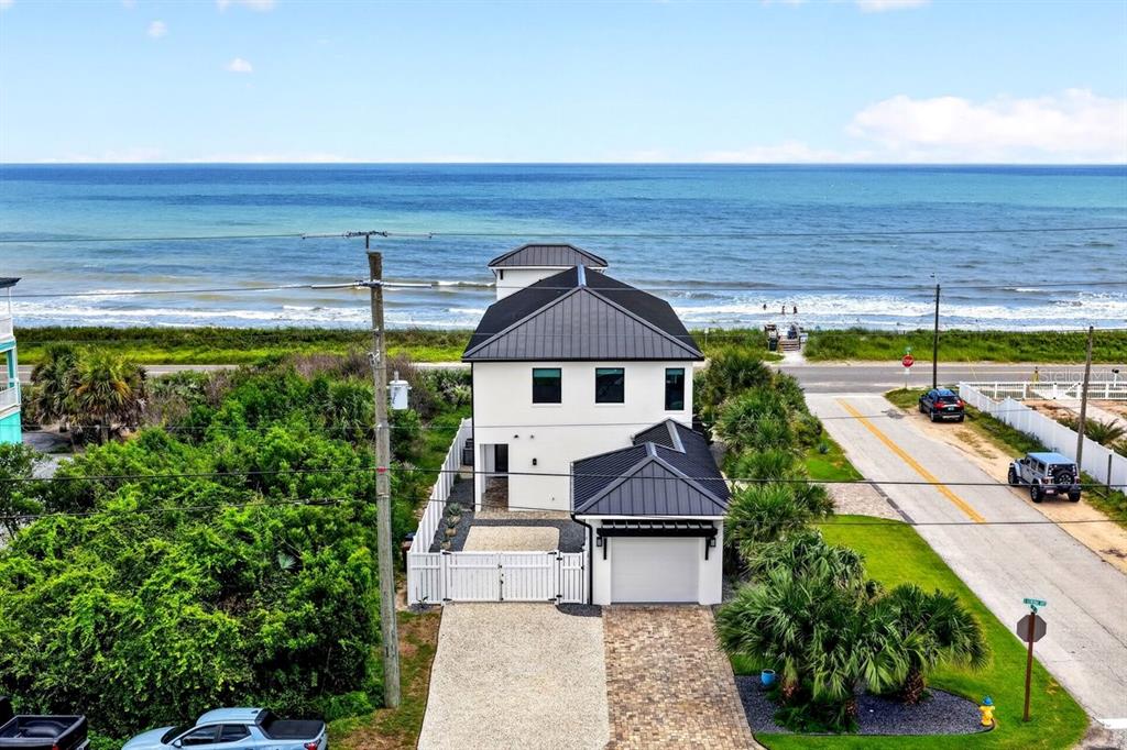 An aerial view of a modern white house with a black metal roof near the beach — 2574 S OCEAN SHORE BOULEVARD, FLAGLER BEACH, FL
