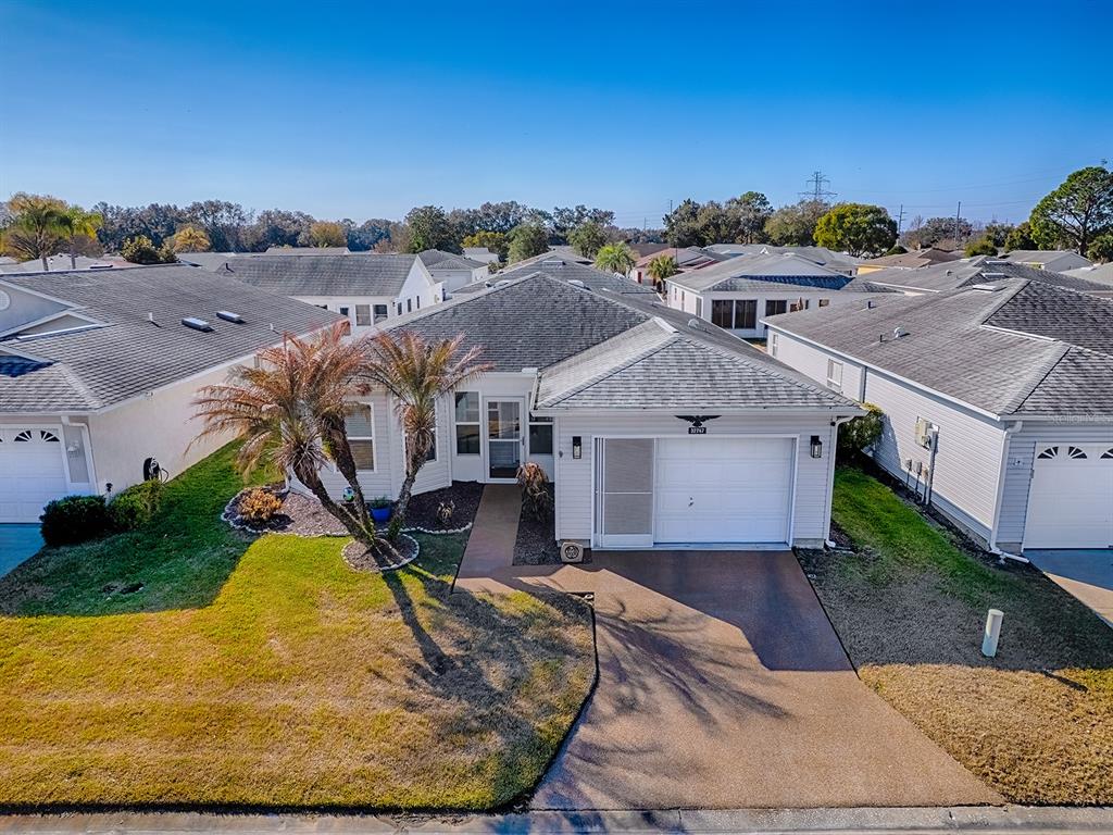 An aerial view of a single-story suburban house with a garage and a palm tree — 32747 WESTWOOD LOOP, LEESBURG, FL