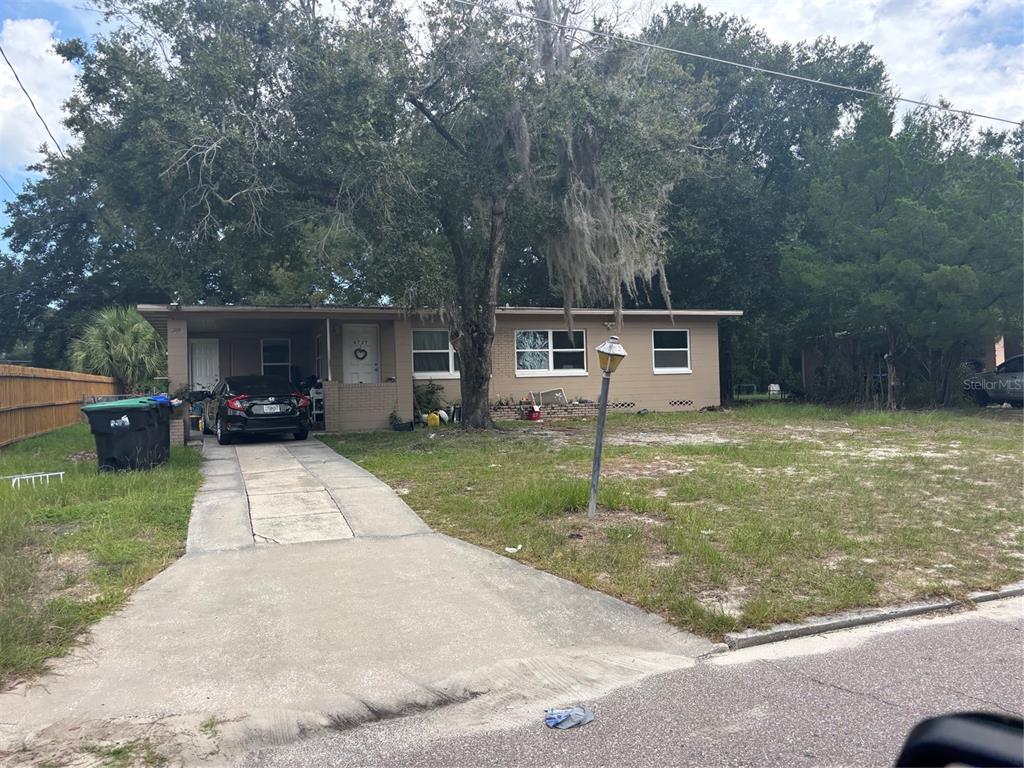 A single-story house with a concrete driveway, a large tree, and a front lawn — 4727 ABACA STREET, ORLANDO, FL