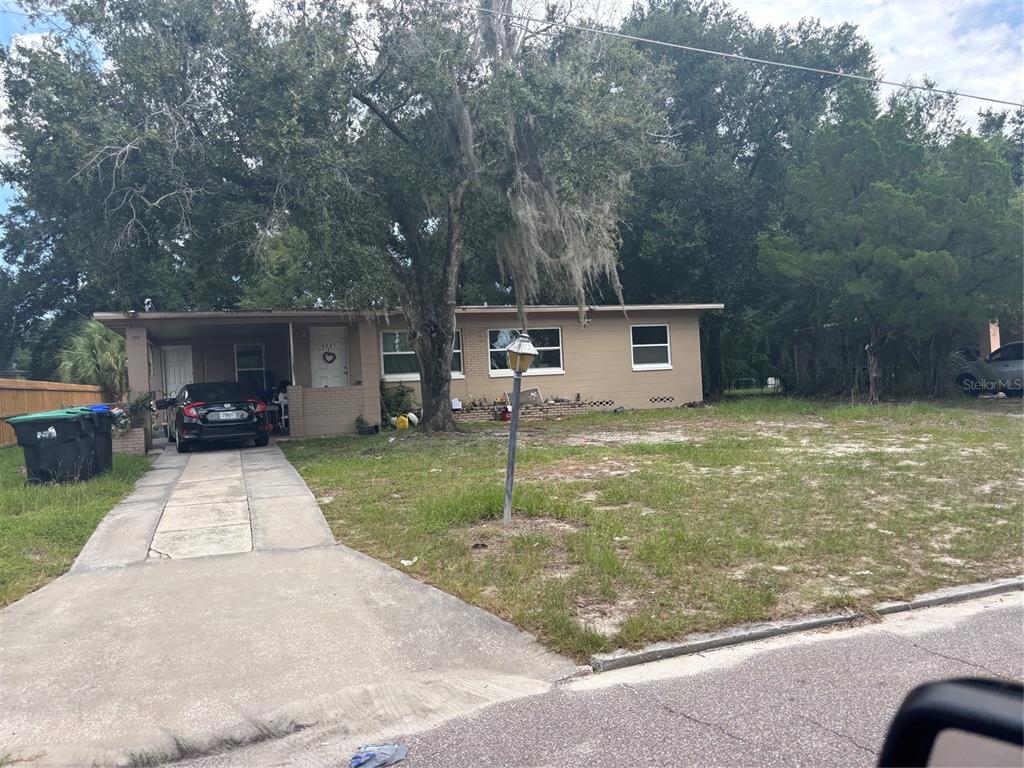 A single-story house with a tan exterior, a carport, and a concrete driveway — 4727 ABACA STREET, ORLANDO, FL