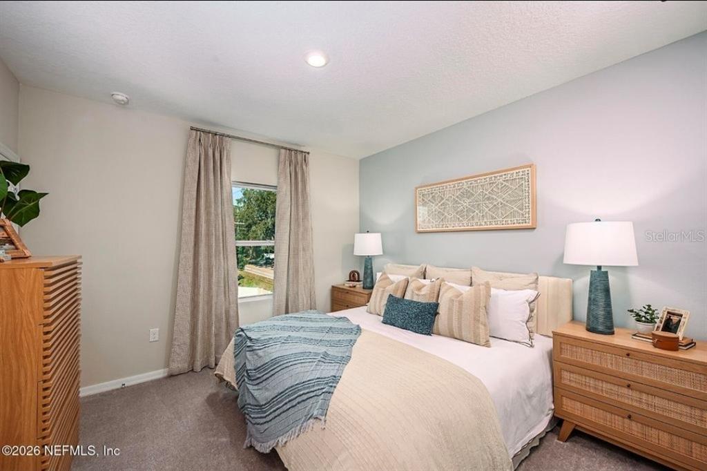 A bedroom features a bed with blue and beige bedding against a light blue wall — 7268 SABAL TERRACE, JACKSONVILLE, FL
