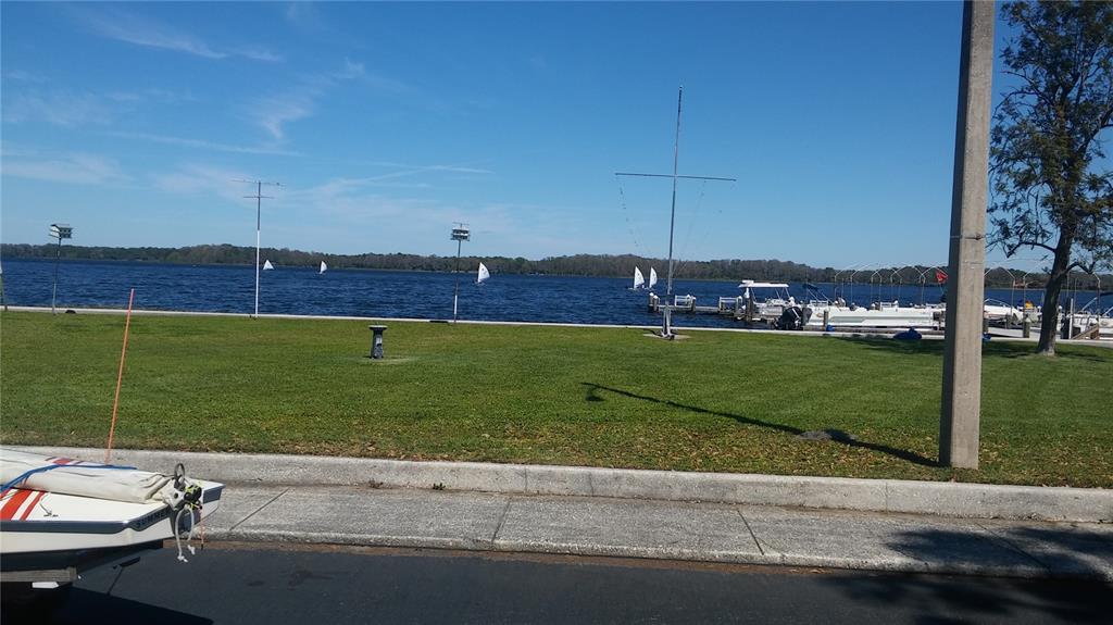 A grassy park area overlooks a lake with several sailboats and a boat dock — 192 NEW ENGLAND AVENUE UNIT 23, PALM HARBOR, FL