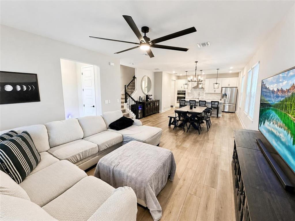 A covered outdoor patio features gray seating, a black metal railing, and a spiral topiary — 4981 CORAL BEAN ALLEY, WINTER GARDEN, FL