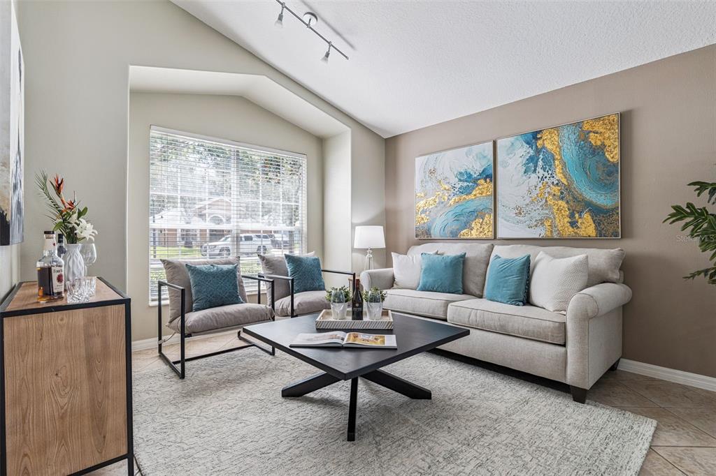 A living room features a beige sofa, two armchairs, a coffee table, and abstract wall art — 1462 BARN OWL LOOP, SANFORD, FL