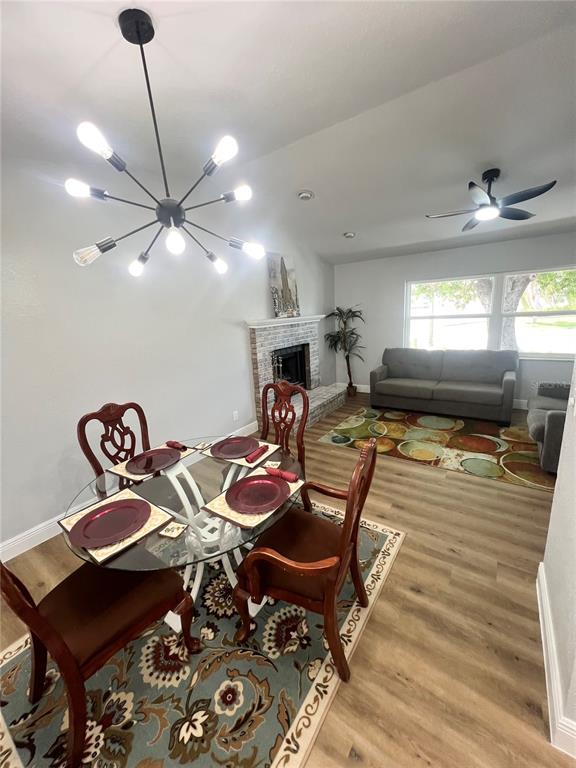 A dining area with a glass table and modern chandelier opens into a living room — 12195 71ST WAY, LARGO, FL