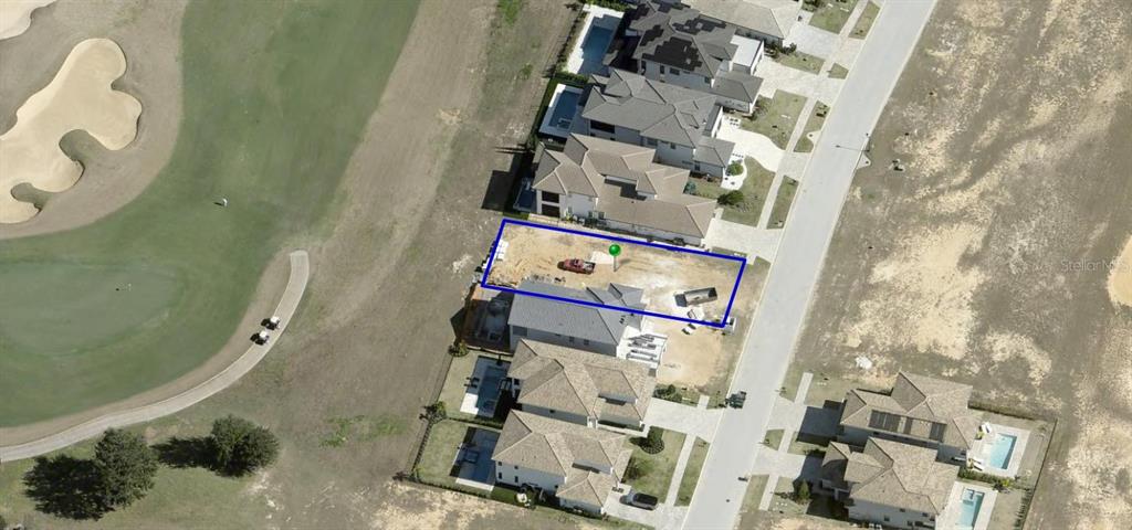 This aerial view shows a vacant residential lot under construction next to a golf course — 15831 VETTA DRIVE, MONTVERDE, FL