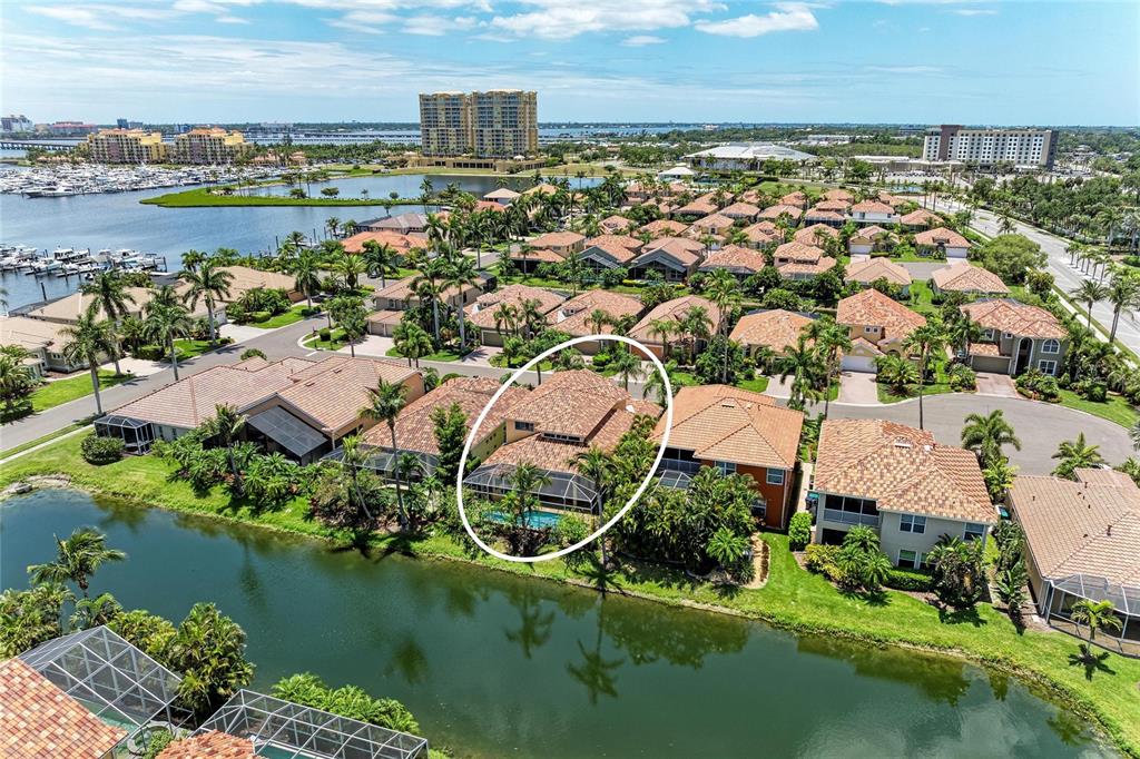 An aerial view shows a residential house with a screened pool deck beside a canal — 308 10TH AVENUE E, PALMETTO, FL