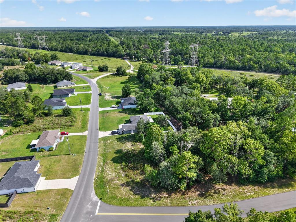An aerial view shows a suburban street lined with houses surrounded by wooded areas — 0000 SW 155TH STREET ROAD, OCALA, FL