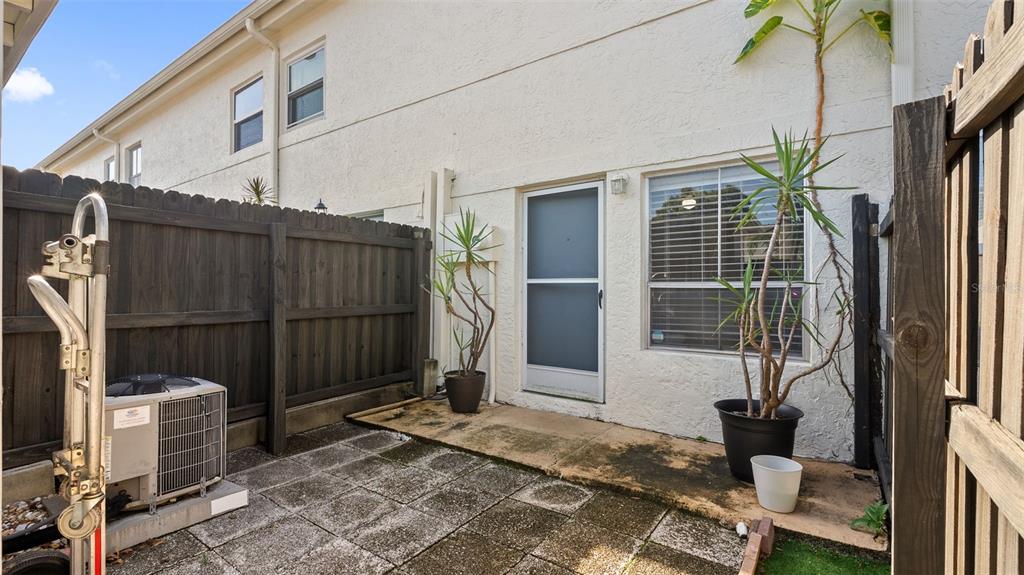 A kitchen with white cabinets, stainless steel appliances, and a dining area with stairs — 4227 LA PALMA COURT, TAMPA, FL