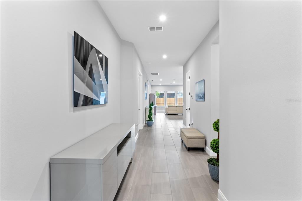 A long hallway with light tile flooring leads to an open living area — 6526 CIRCLE ROCK WAY, ST CLOUD, FL