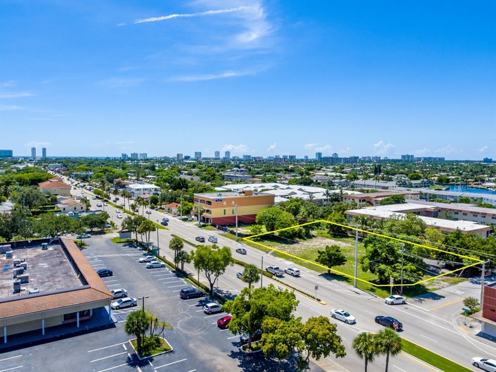 An aerial view shows a vacant, rectangular lot outlined in yellow along a busy street — 600 E ATLANTIC BOULEVARD, POMPANO BEACH, FL
