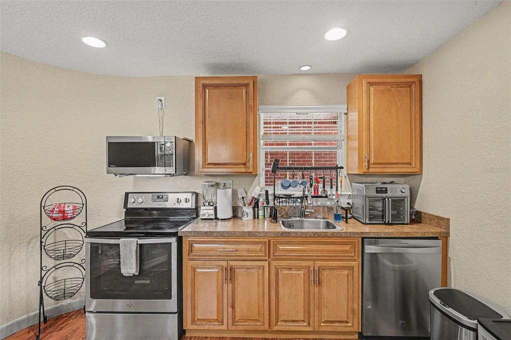 A kitchen with wood cabinets, stainless steel appliances, a sink, and a window — 2625 GARDEN STREET, TITUSVILLE, FL