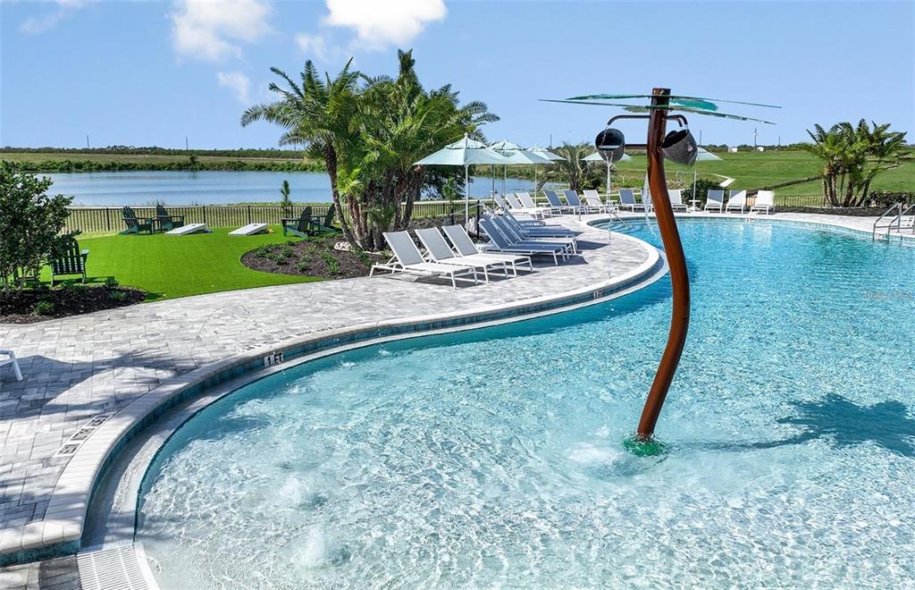 A swimming pool with a water feature sits beside a patio with lounge chairs and landscaping — 465 WATERFORD DRIVE, LAKE ALFRED, FL