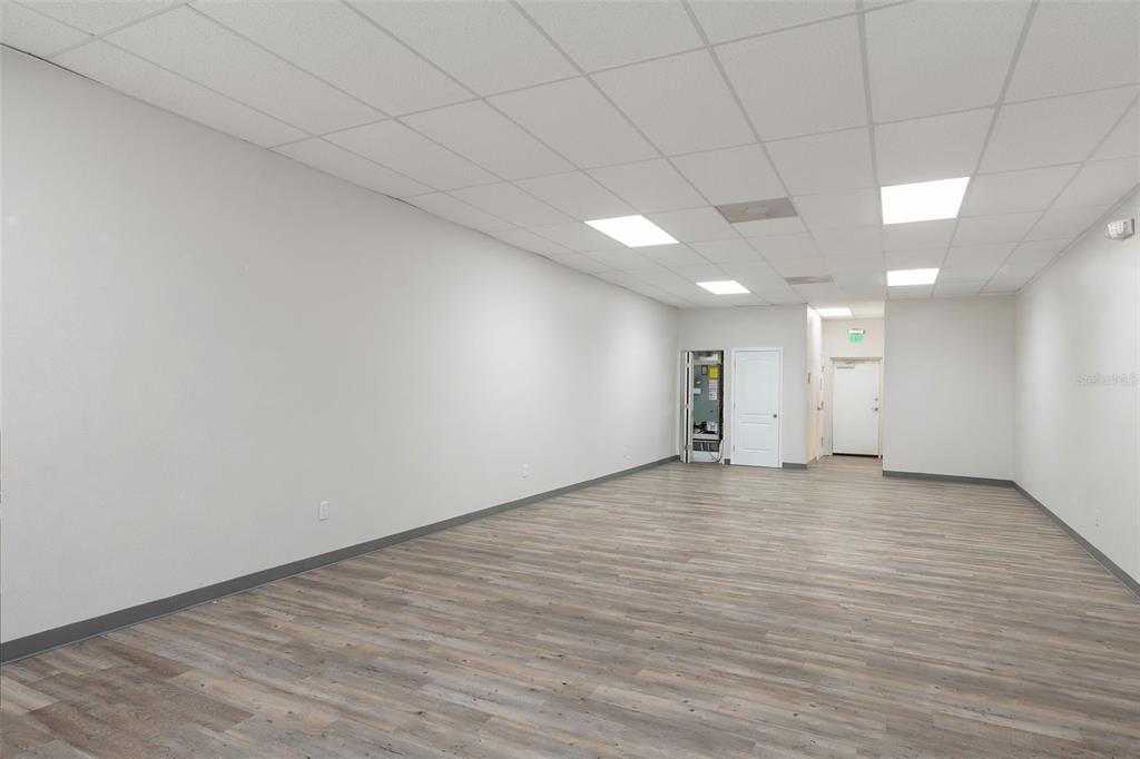 An empty commercial office space with light gray walls, wood-look flooring, and a drop ceiling — 1298 E NORVELL BRYANT HIGHWAY, HERNANDO, FL