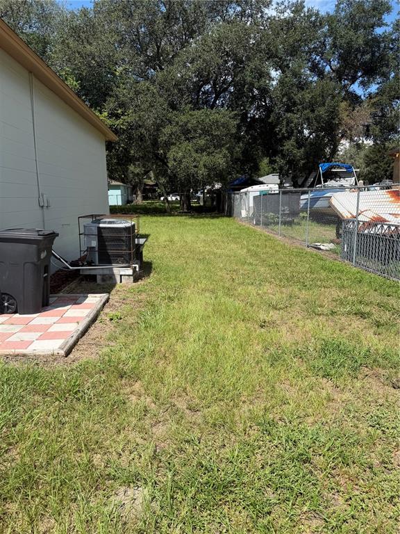 A side yard features a grass lawn, an air conditioning unit, and a chain-link fence — 21015 MARKET STREET, DADE CITY, FL