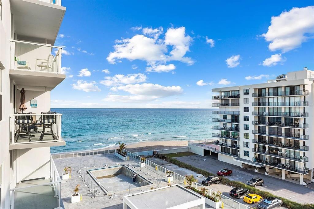 An elevated view of a beachside apartment complex with a pool and ocean view — 3450 S OCEAN BOULEVARD UNIT 615, PALM BEACH, FL