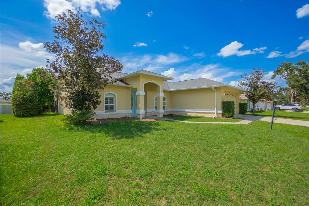 A single-story yellow house with a light blue front door and a two-car garage — 3200 S FRANKLIN TERRACE, INVERNESS, FL