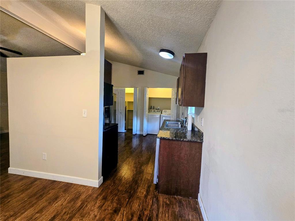 A living room with wood-look flooring, a stone fireplace, and a vaulted ceiling with fans — 13581 SE 48TH COURT, SUMMERFIELD, FL