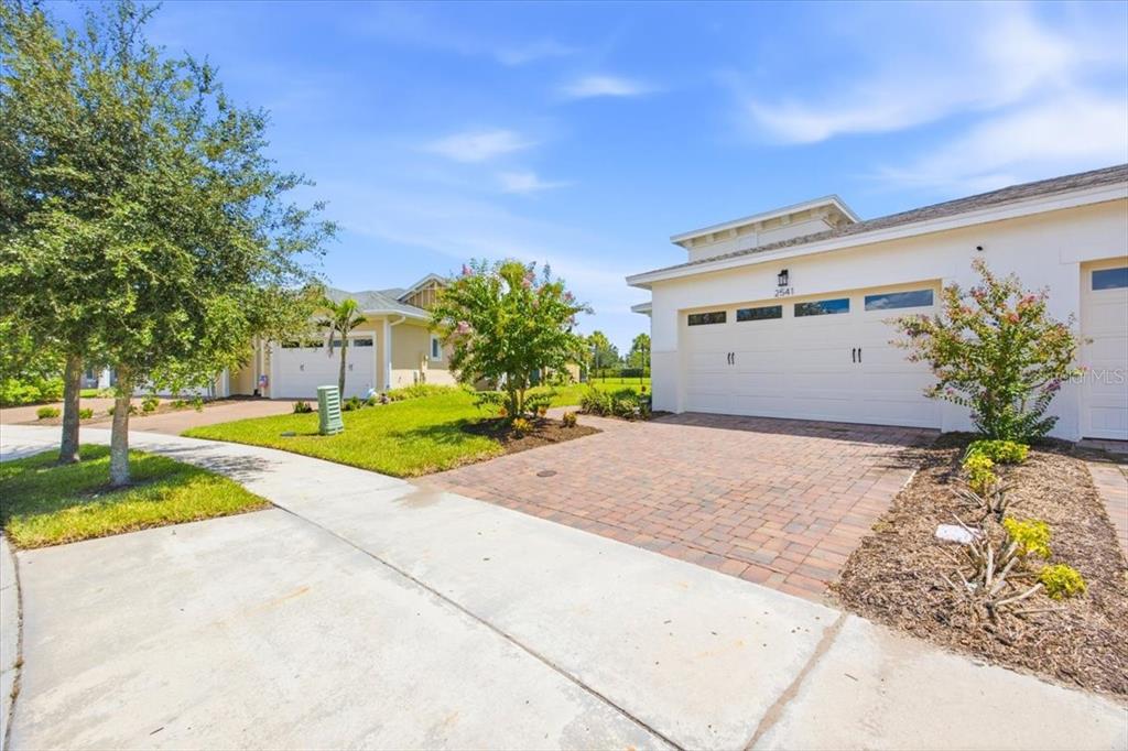 A view of a suburban house exterior with a paved driveway and a two-car garage — 2541 YELLOW BRICK ROAD, ST CLOUD, FL