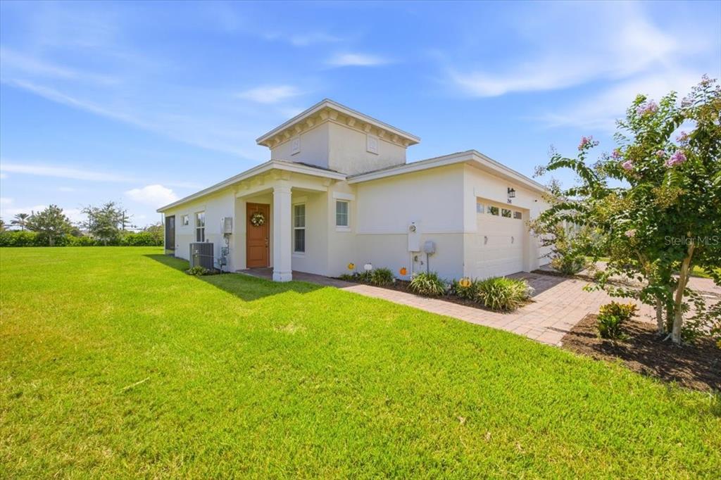 A single-story house with a white stucco exterior, a front porch, and a paved driveway — 2541 YELLOW BRICK ROAD, ST CLOUD, FL