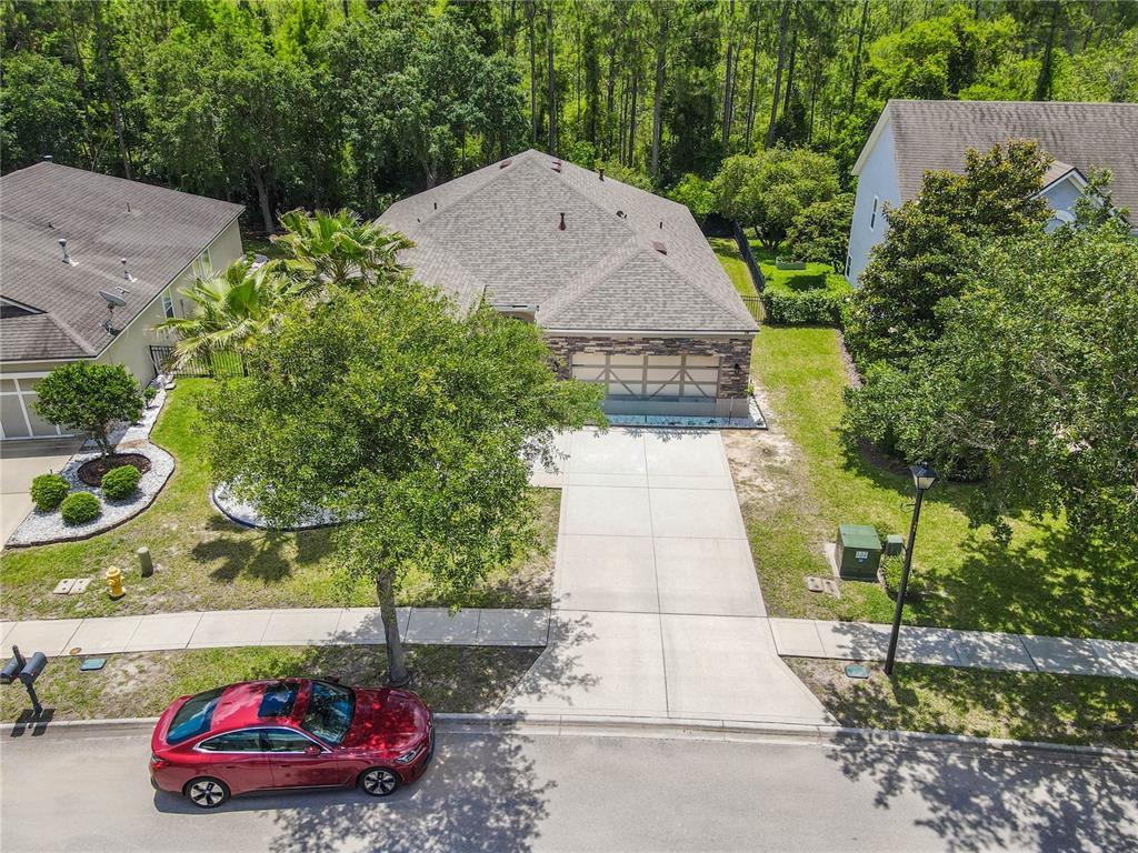 An aerial view shows a single-story house with a stone facade and a concrete driveway — 184 S ARABELLA WAY, ST JOHNS, FL