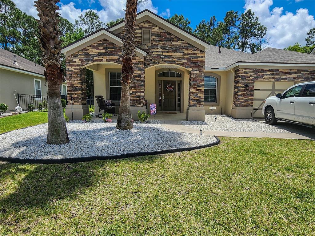 A single-story house with a stone facade, a covered entryway, and a white pickup truck — 184 S ARABELLA WAY, ST JOHNS, FL