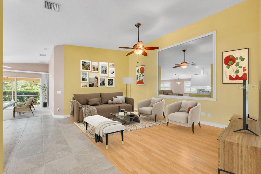 A living room with yellow walls, a brown sofa, two armchairs, and a large mirror — 7617 CAMMINARE DRIVE, SARASOTA, FL