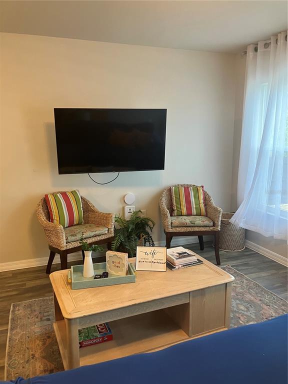 A living area features two wicker chairs, a wooden coffee table, and a wall-mounted television — 4109 NE 20TH PLACE, CAPE CORAL, FL
