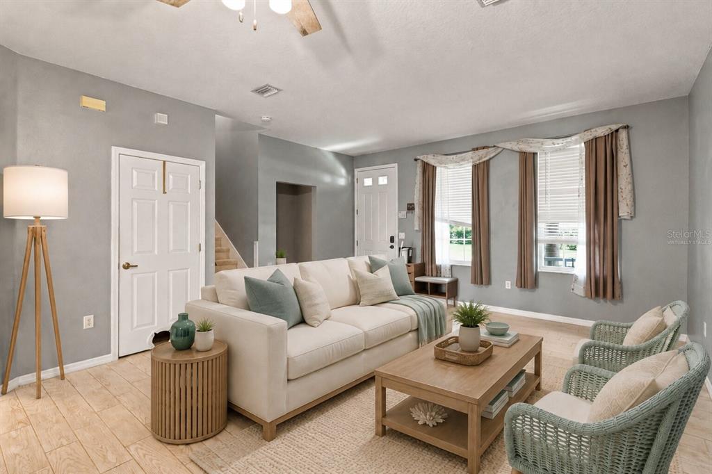 A living room features a beige sofa, two wicker chairs, a coffee table, and tile flooring — 34928 TEEVIEW LANE, ZEPHYRHILLS, FL